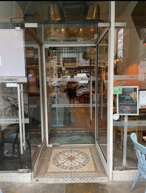 From street, facing venue. Glass door ahead. Silver handle on right. Push to open.