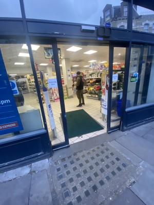 This is the main entrance of a small Tesco in Fulham. There are no steps or numbs & the doors are automatic sliding glass doors.