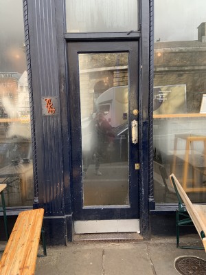 Glass door with dark blue wooden frame. Push from right.