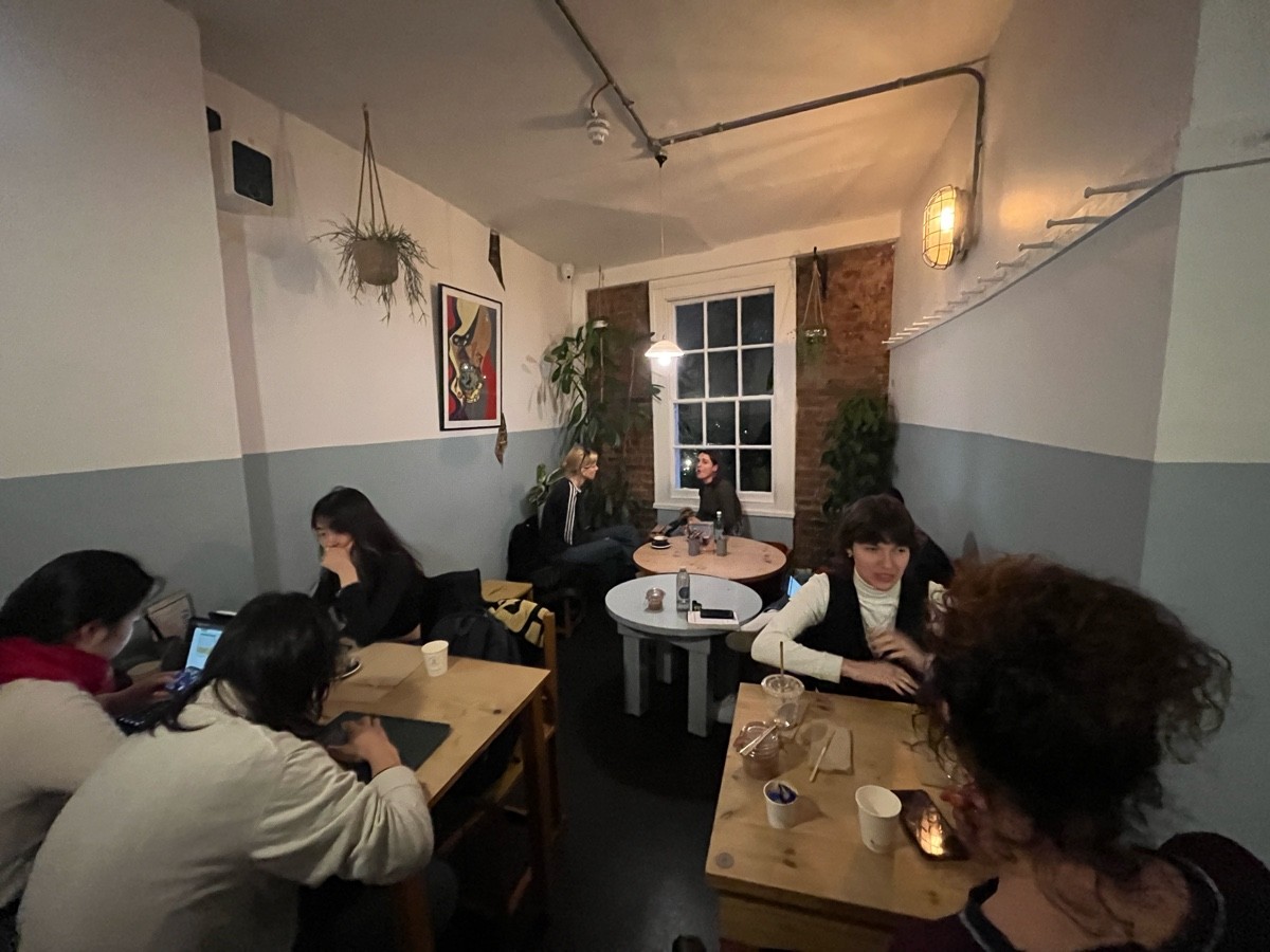 From tables and chairs facing right. Tables with chairs and stools ahead followed by low tables with chairs and benches.