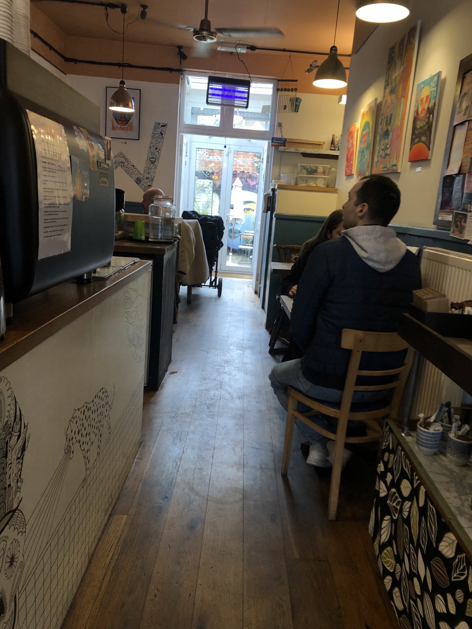 Tables with seating for two people. The area behind the counter.