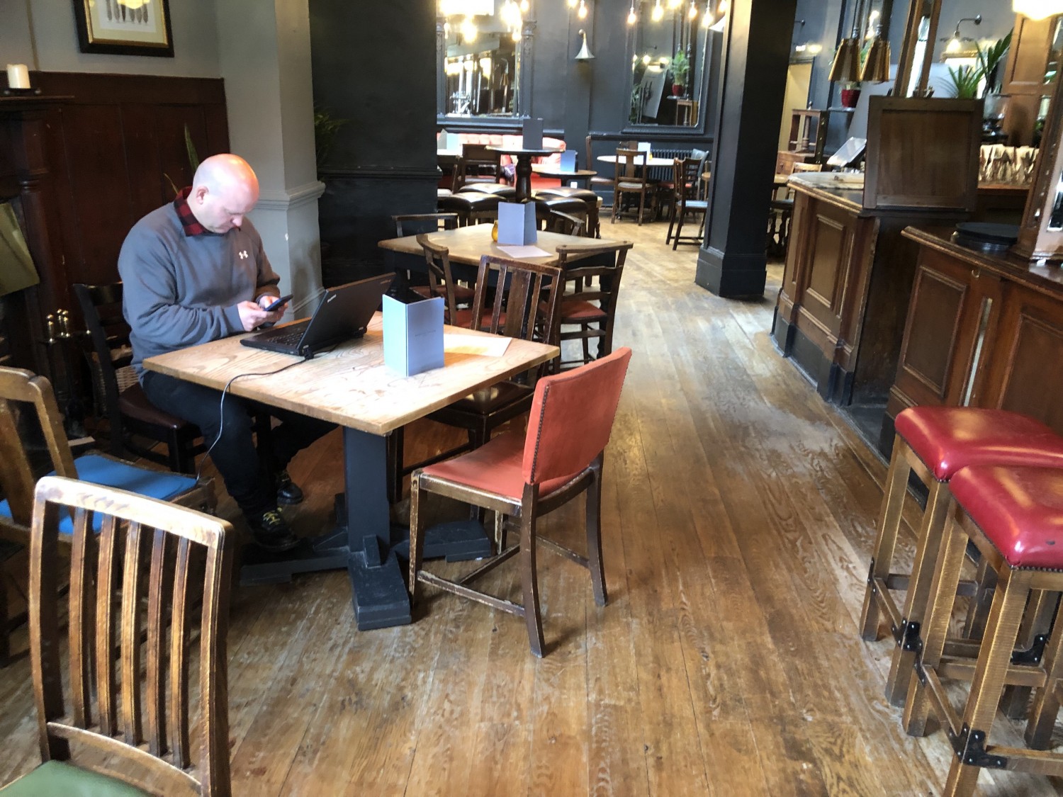 Photo of back left of main area with tables and chairs along the left wall. Back area is at the back of this area.