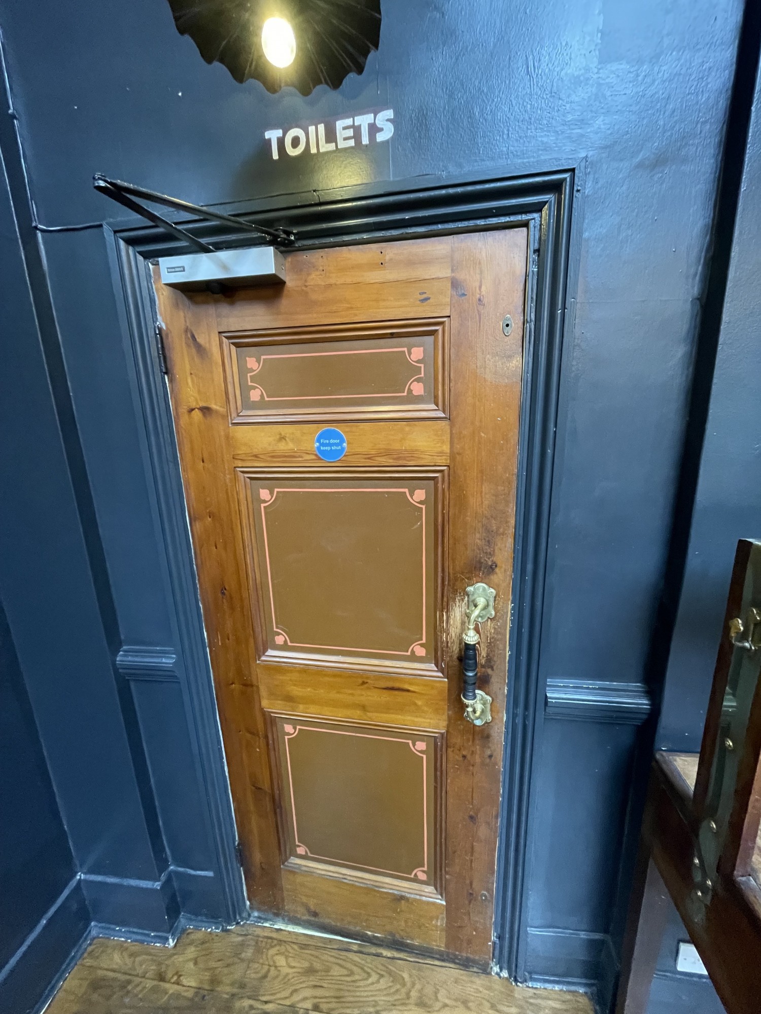 First preceding door to bathroom areas it is a pull door with handle at centre height of door. It is on the right of the door. Pull from the right.