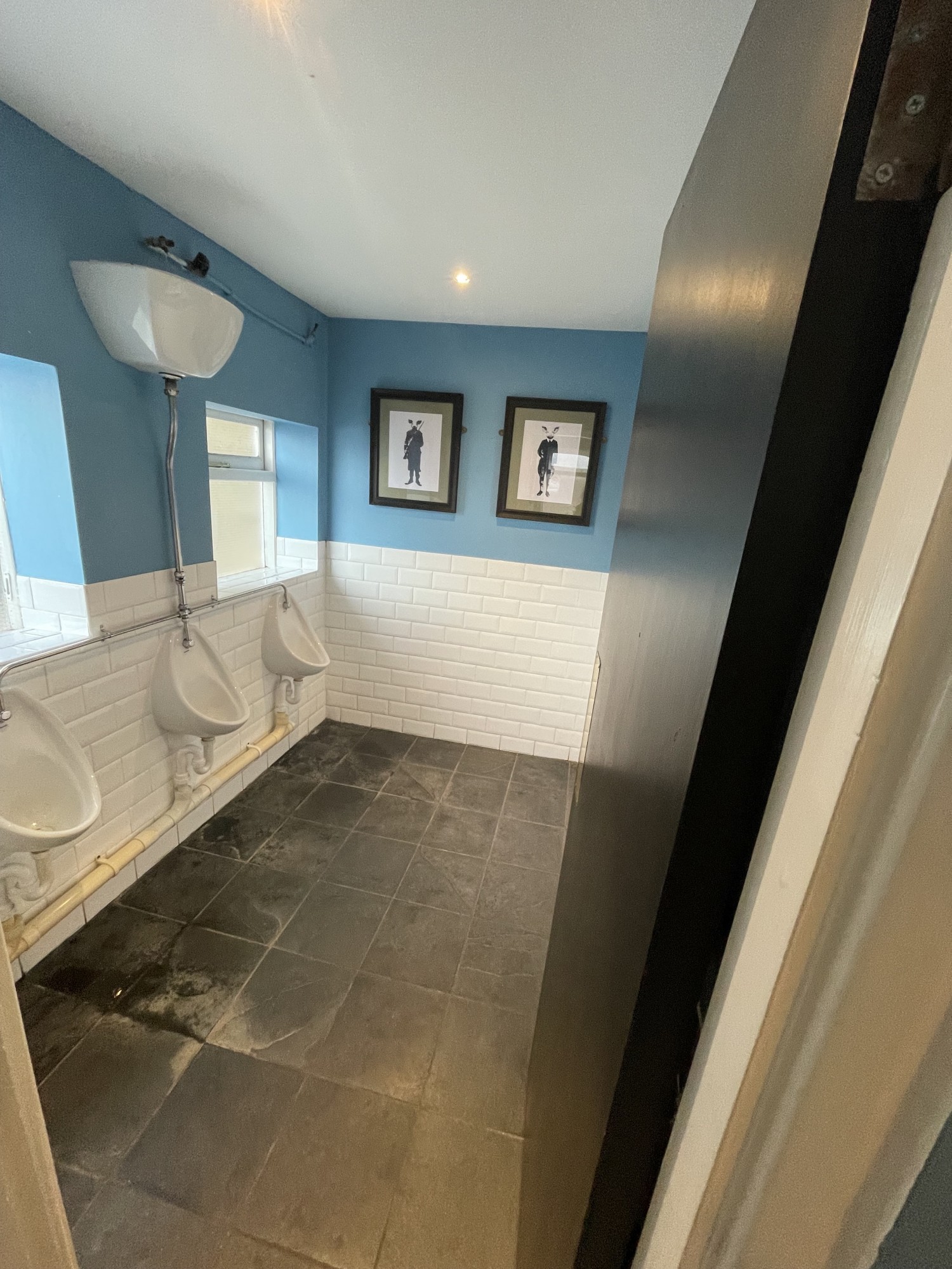 Urinal men’s area. Urinals are on the left wall. There are 3. This room to found to the right. There is a push door to enter. The door should be pushed from the left.