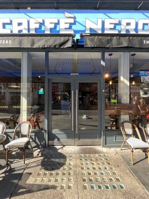 Metal-framed glass doors ahead. Push silver vertical handles at centre to open.