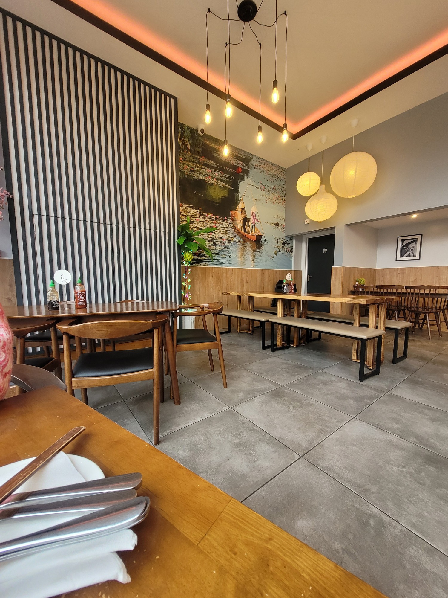 Left side of restaurant, with larger tables that can accommodate 4 to 8 people. Options of bench seating. Along the back wall is the door leading to toilets.