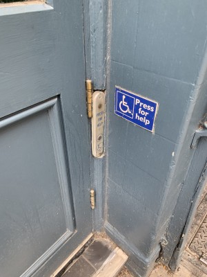 Doorbell for assistance on right side of door.
