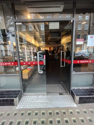 Glass double door with handle in centre, push to open.