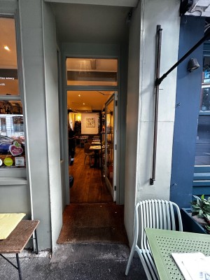 Entrance glass single door with golden handle on mid left. Push to open.