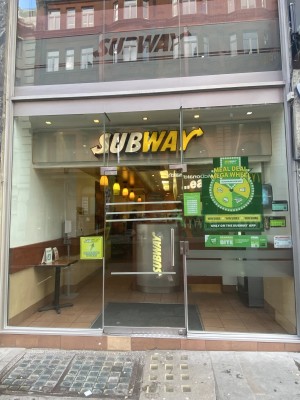 Glass door with metal handle on right. Push door to open.