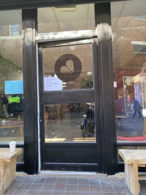 Glass door with black frame ahead. Push from right to open.