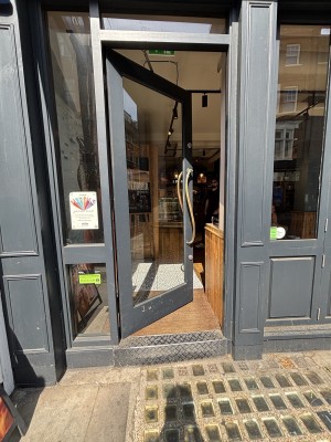Glass door with black frame ahead. Push from right to open.