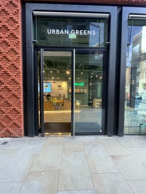 Tall metal-framed glass doors ahead. Push silver vertical handle at centre to open.