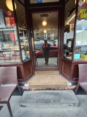 Wooden glass door with handle at left, push to open.