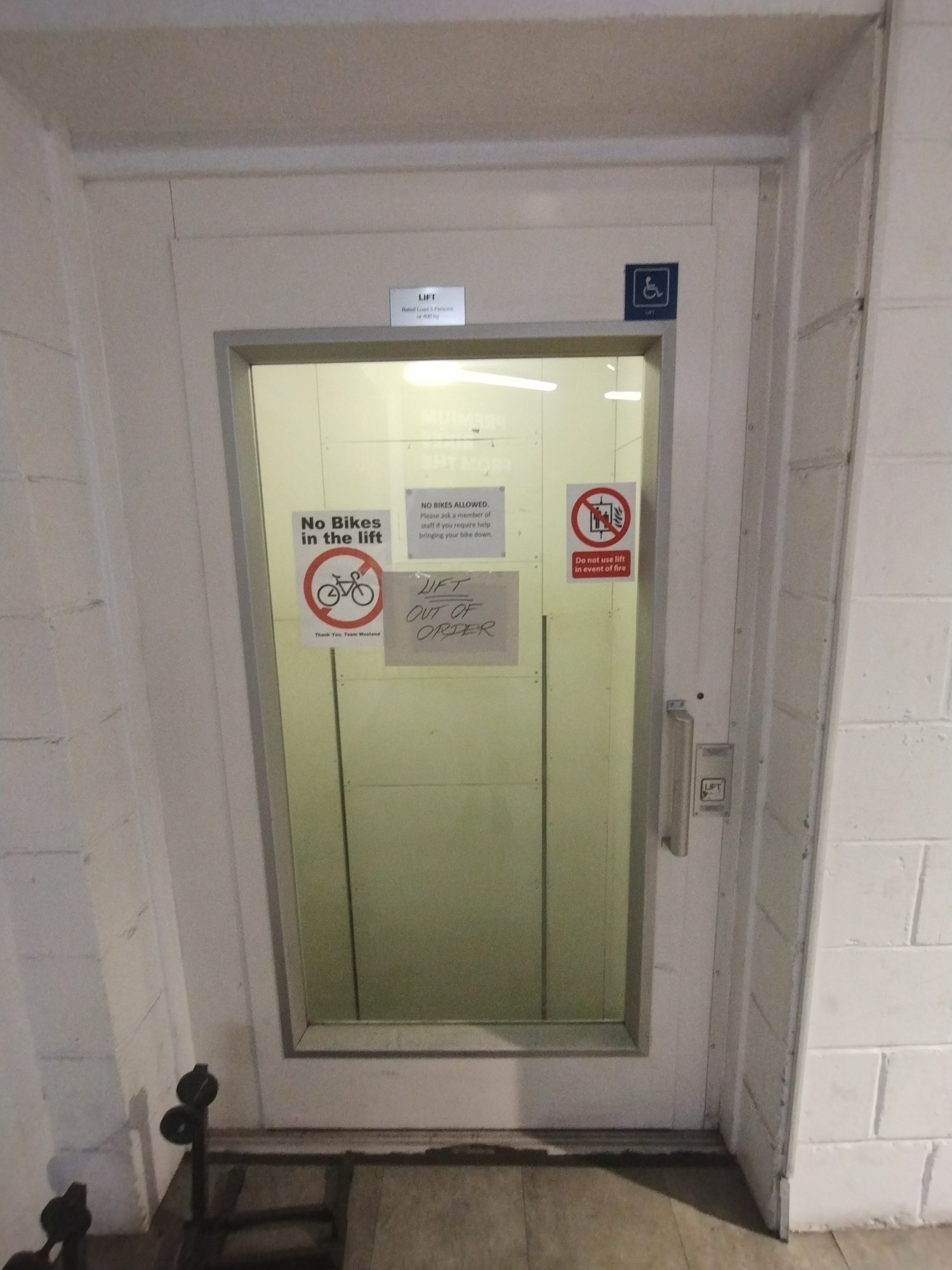 Picture of lift leading to downstairs area. You find the lift at the right after the stairs. The button to call the lift is at the right. You have to pull the door open to the left. The handle is at the right.