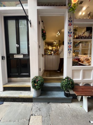 Single white wooden door with glass panels. Push gold metal handle from right to open.