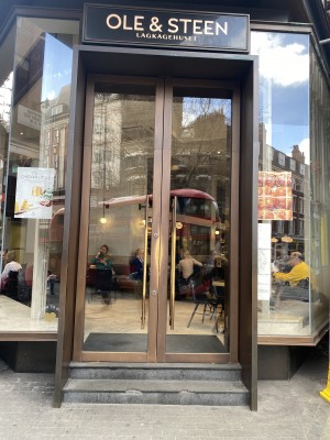 Double glass doors with gold metal vertical handles along middle. Push to open.