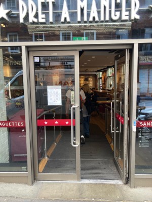 Access via double glass door with metal frame. Push open via vertical metal handrails in center.