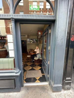 Black glass door with handle at left, push to open.