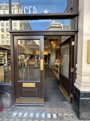 Brown and glass panelled doors with gold pads in centre of doors. Push to open.