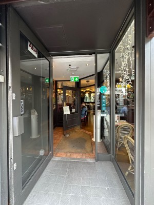 Glass door with grey doorframe. Grey handle to right of door. Pull to open.