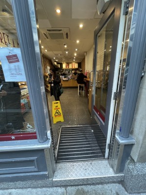 Glass door, with grey doorframe. Silver handle on left. Push to open.