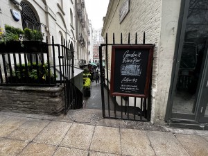 View of the main entrance. There is a grill gate, which pushes open from the middle. Stairs after the grill gate to access the outside seating area.
