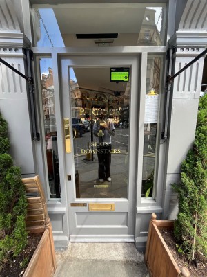 White framed glass door. Push from left to open.