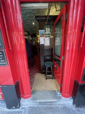 Door is a push door to be pushed from the left. There is no handle. There is a step before the door and two small bumps upon entering the door.