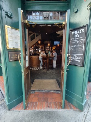 Green framed glass door. Pull golden metal handles in centre to open.