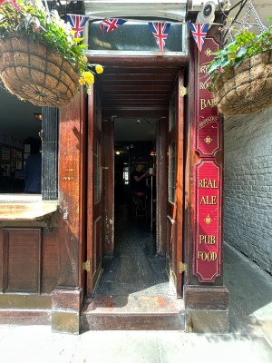 Preceding double dark wooden doors with glass panels. Push from middle to open.