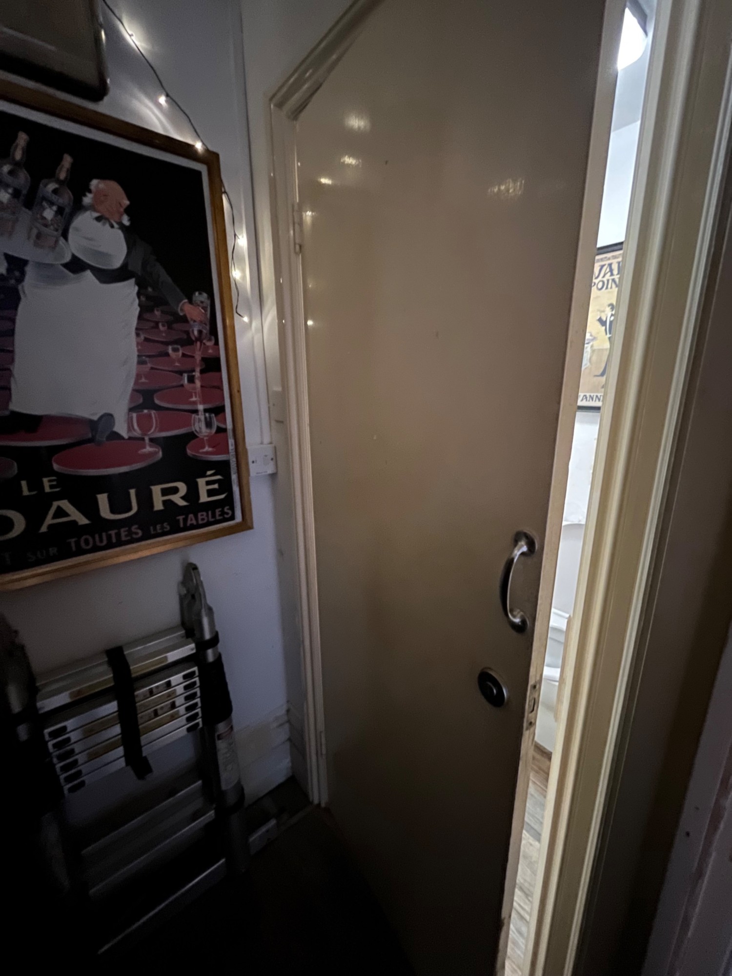 From door facing right. Single white wooden door ahead. Pull silver metal handle from right to open.