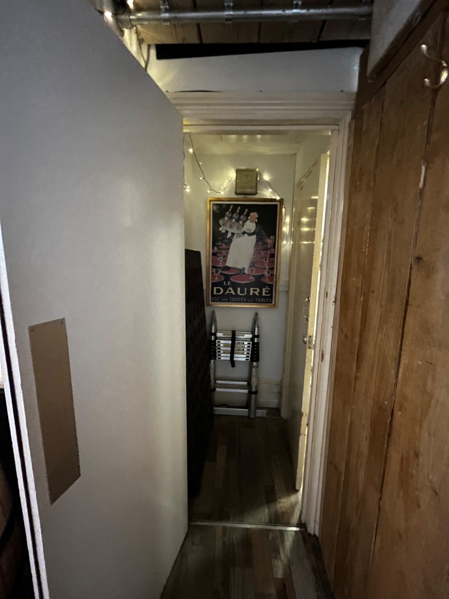 From door facing left. Single white wooden door ahead. Pull silver metal handle from right to open.