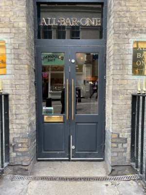 Glass and wood panelled doors with brass handles in centre. Manual doors, pull to open.