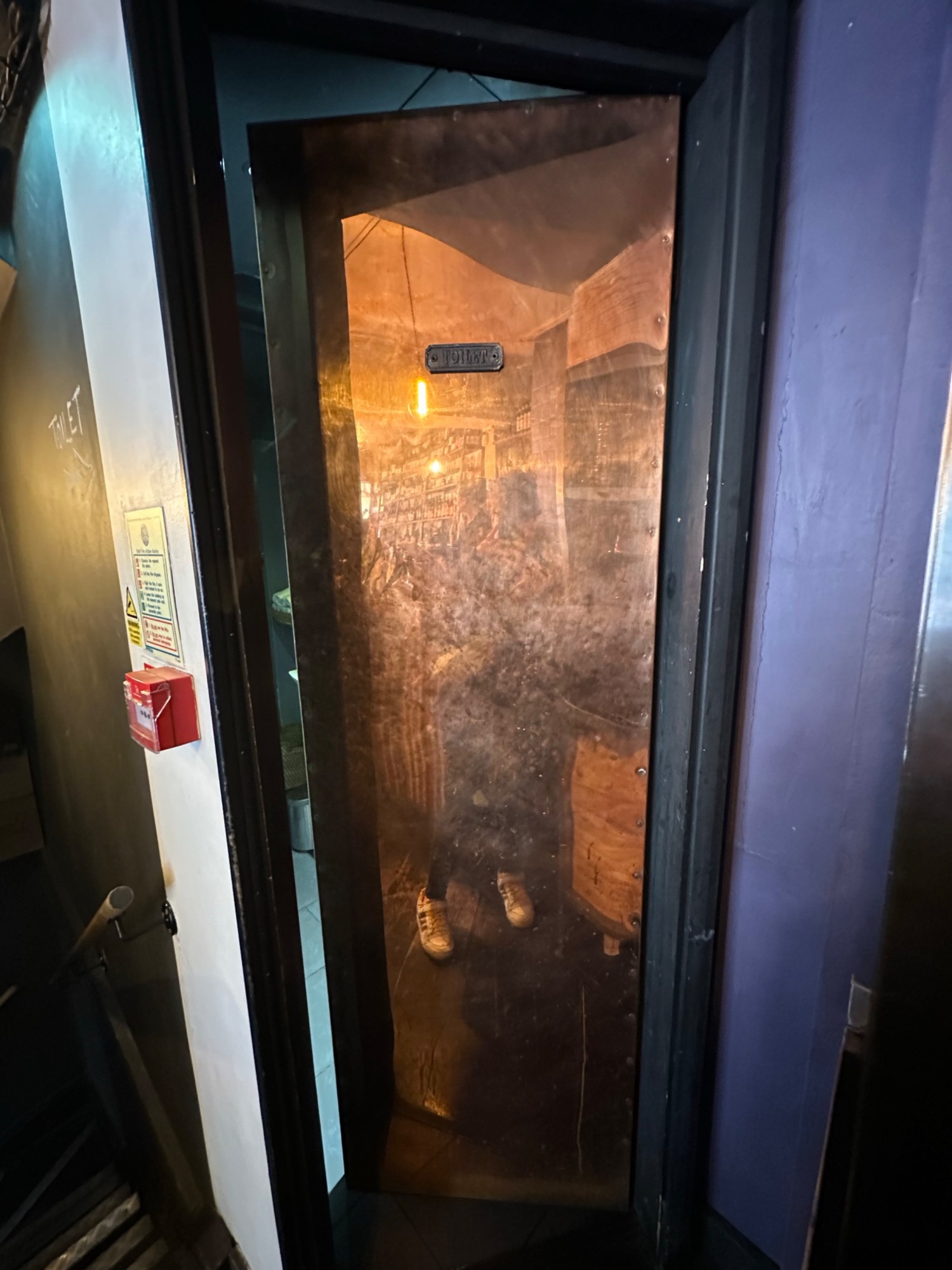 From end of path looking left at brass bathroom door. Push from left to open.