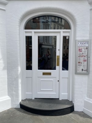 White framed glass door. Push open from right side.