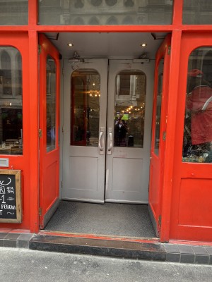 Directly facing the entrance of the pub from the foot path. There is one step along front to access the venue. After step there is a flat area about 1 metre before you reach the door. Door handles are in middle of doors and left door opens outwards.