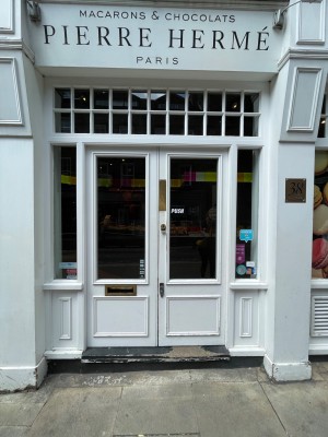 White glass double doors with handles in centre, push to open.