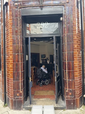 Black wooden doors with glass panels. Pull gold handle on right door from middle.