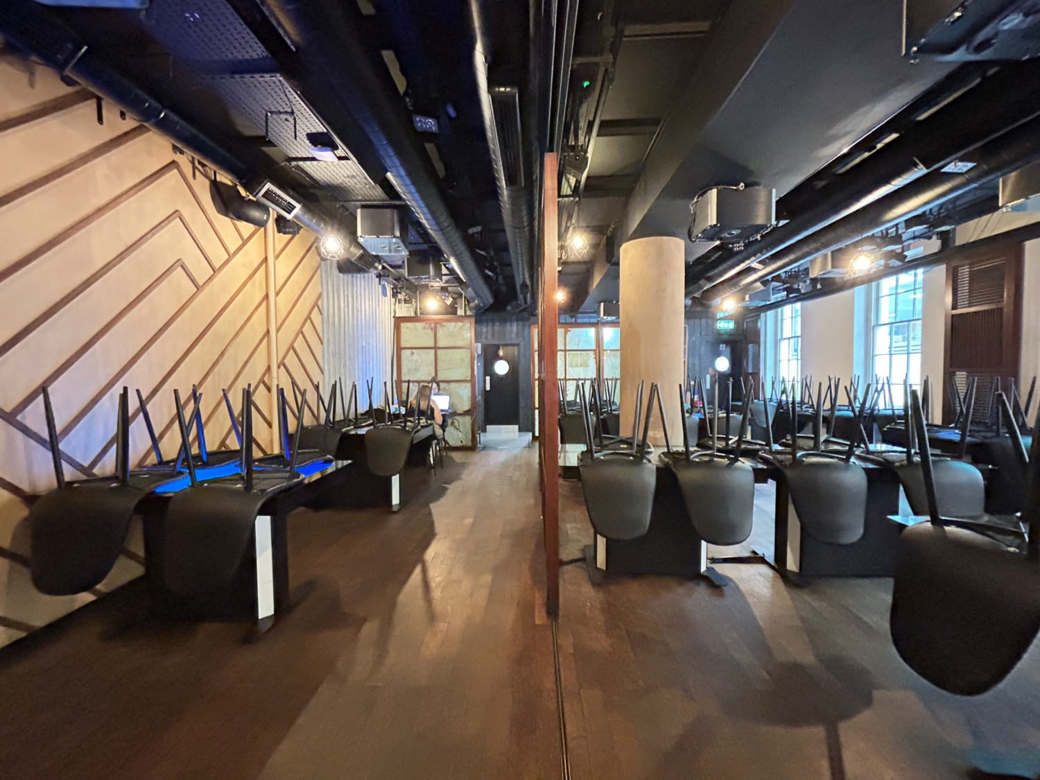 From start of tables, facing right. Tables and chairs along left and right. Path in middle obstructed by divider on right.