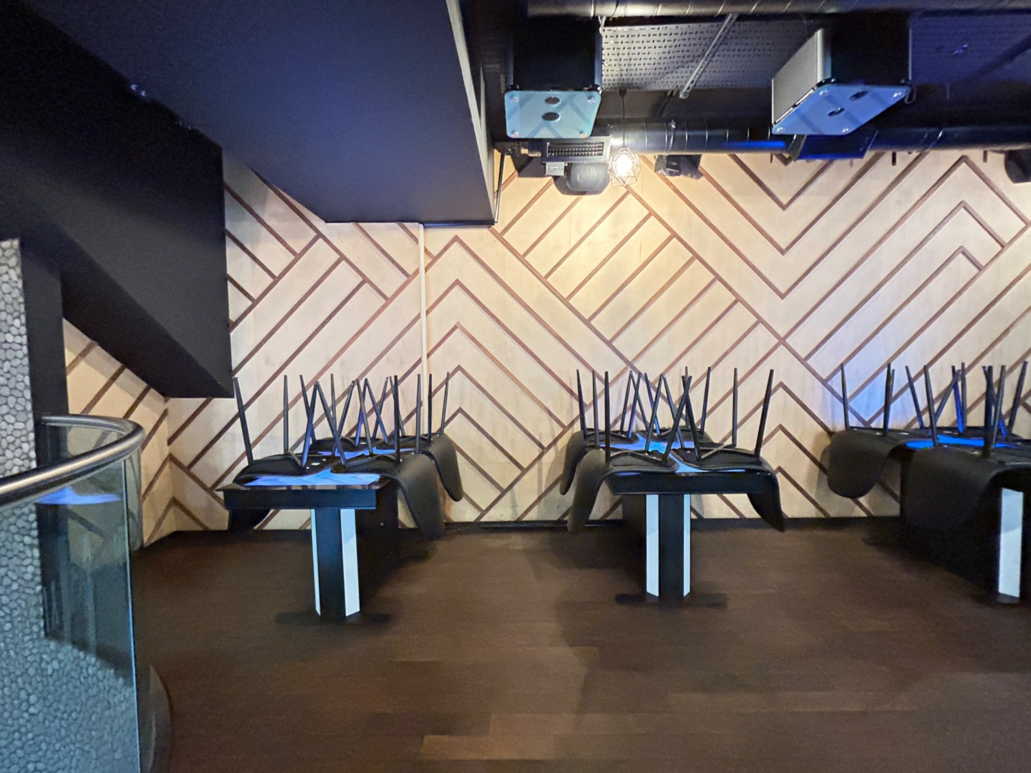 From divider, facing left. Path ahead, then on right. Tables with order screens and chairs along back wall.