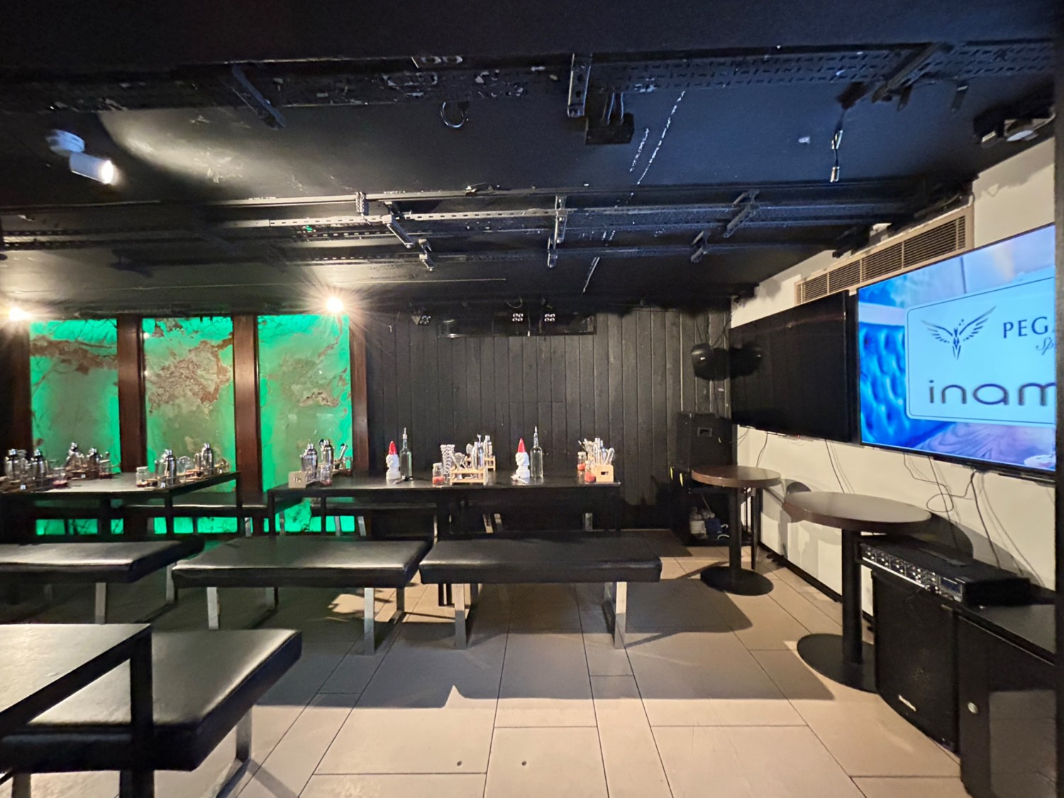 From middle of high tables, facing right. Path ahead, then to left leads to tables and benches along back wall and on left.
