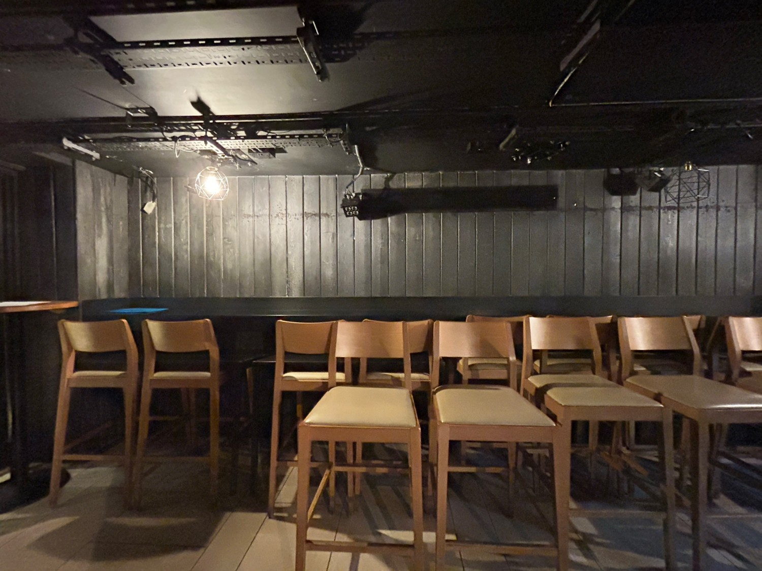 From doorway, facing left. High tables and stools along back wall.
