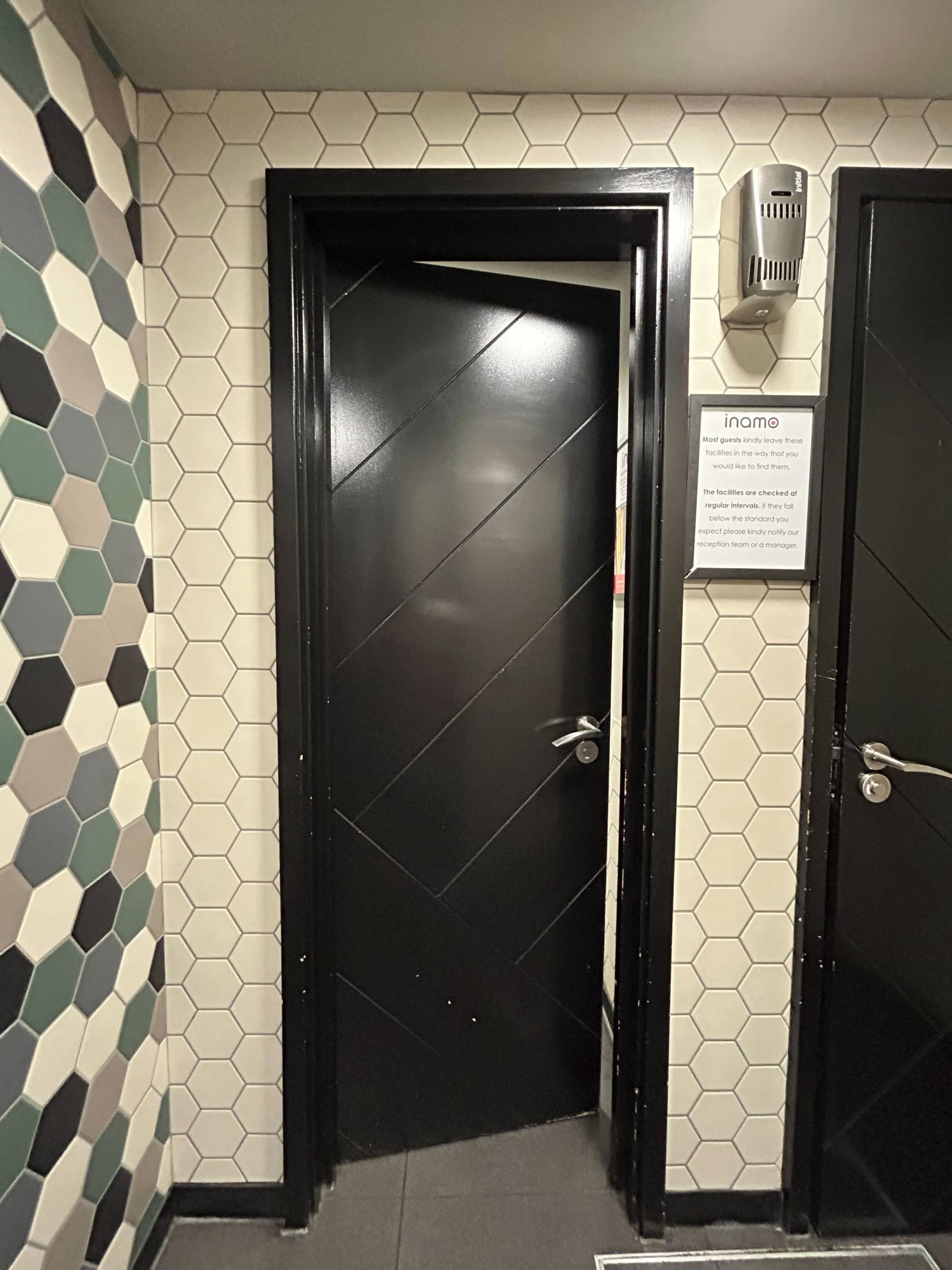 Black door with silver handle on right, push to open.
