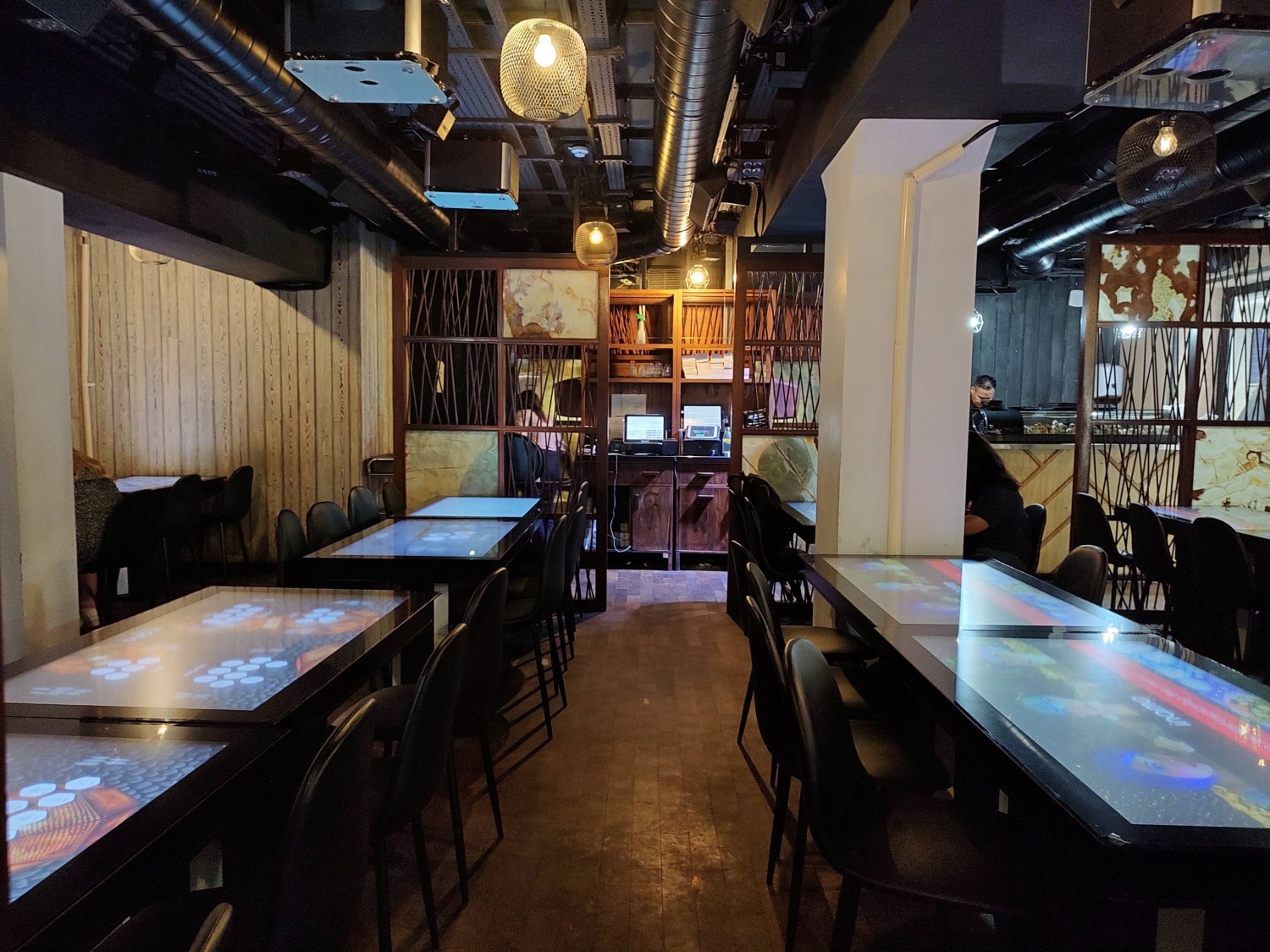From after partition, looking straight. Tables and chairs on both sides. Wooden partition at back.