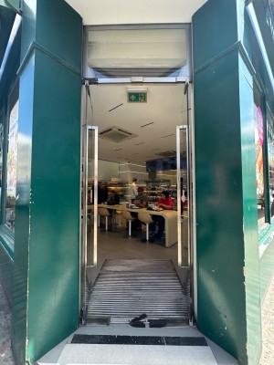 Glass doors with silver handles in centre of doors. Push to open.