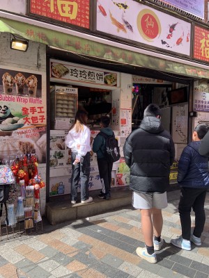 Venue is a hole in the wall up a step. There is a very high countertop. To the right of venue are stairs to a shop.