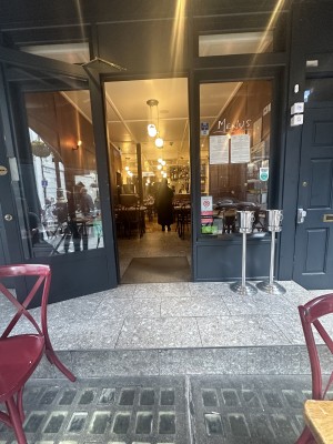 One step. Main glass with wood frame door. Pull door.
