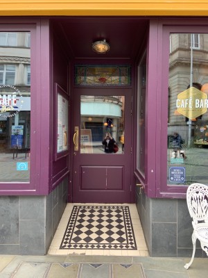 Main entrance to left of venue, dipping back from front window up a built in ramp from street. Pull to open from left.