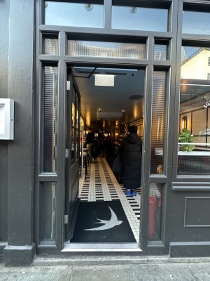 Main glass and wood entrance. Handle on the right. One step.